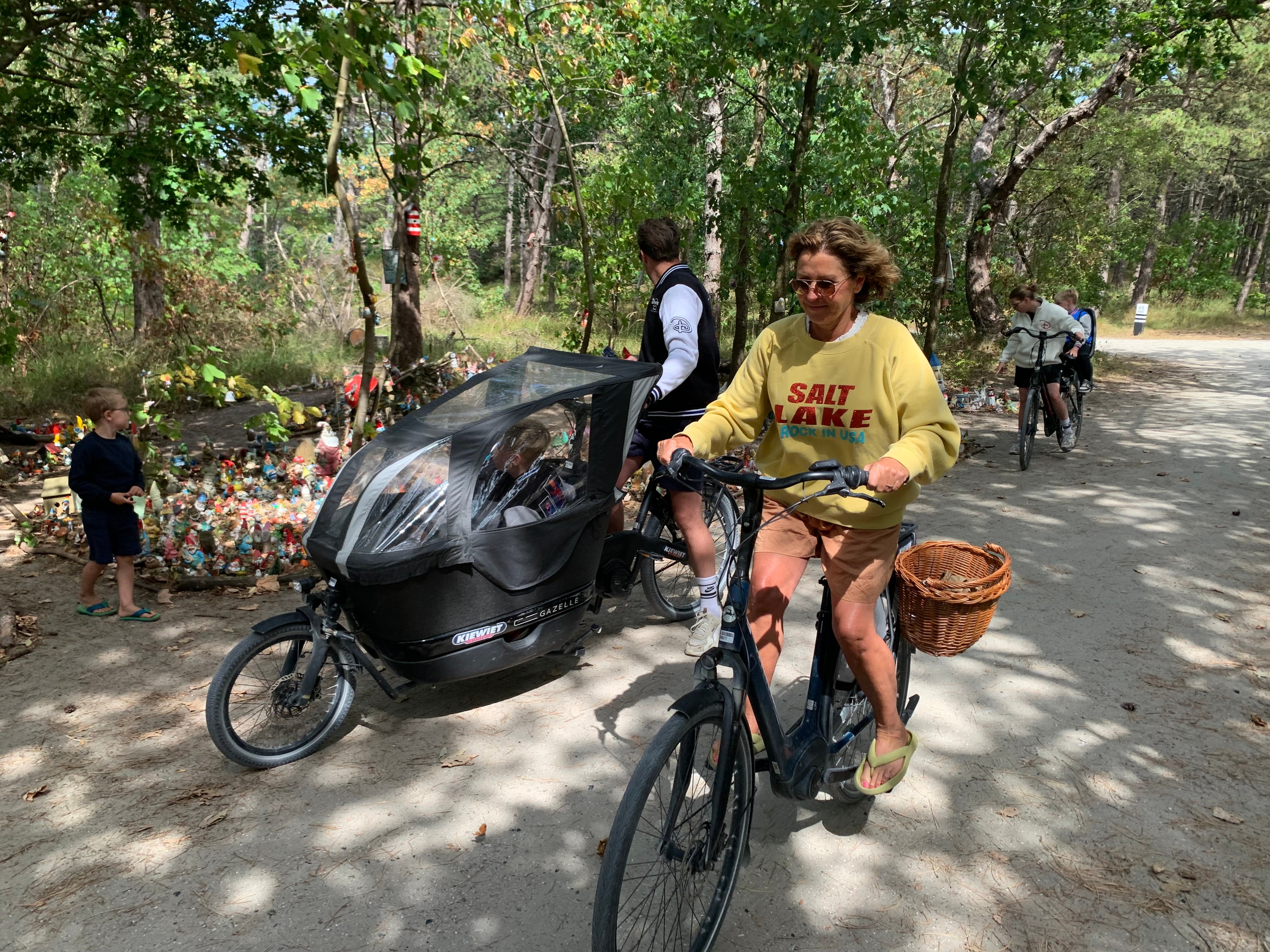Gasten fietsen door het bos langs regionale attracties bij een vakantiepark