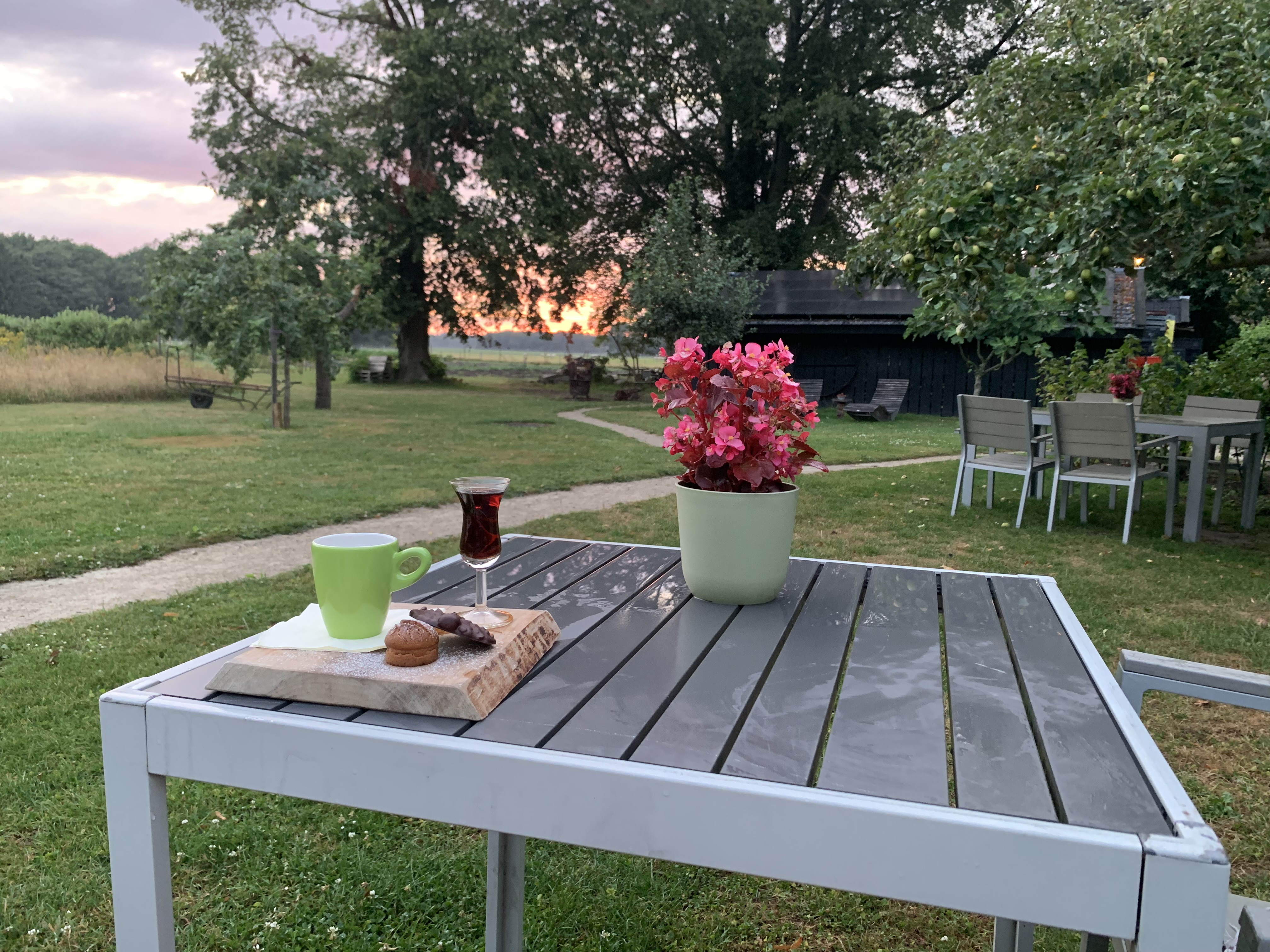Terrastafel met koffie, thee en gebak in een natuurlijke omgeving bij zonsondergang